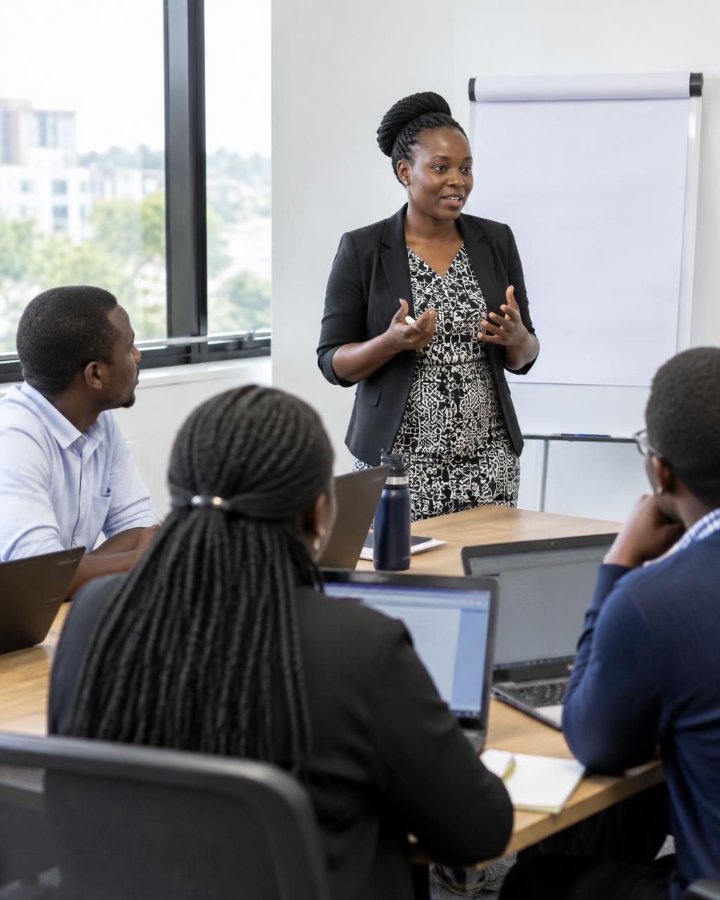 A trainer leading a data skills workshop with participants on laptops